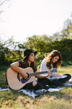 teen girl playing guitars and singing outdoors 