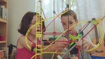 Boy and girl building a tower from toys at home