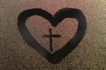 water droplets on glass and heart with cross