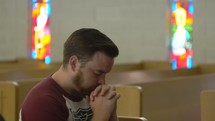 a man praying alone in a church 