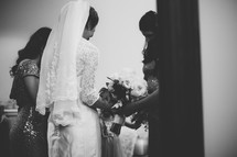 bride and bridesmaids with heads bowed in prayer 