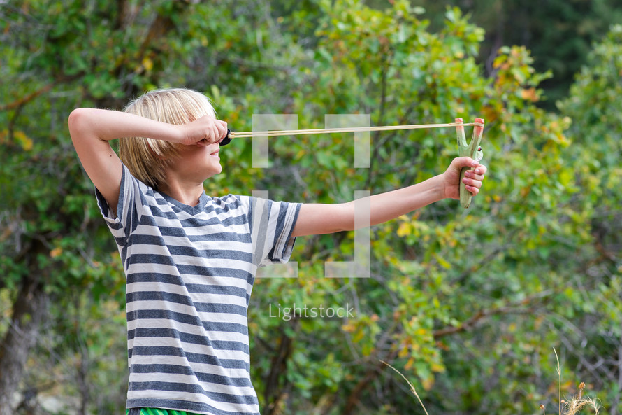 a boy child with a slingshot 