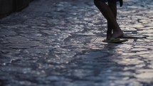 walking with flip flops over paving stones closeup