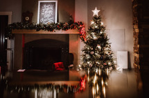 Christmas tree and lights reflecting on a wood table 