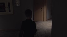 Child walking in hotel hall and opening room door with keycard