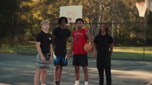 Portrait of smiling young men after playing basketball on a sunny day