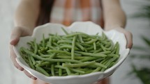woman holding a bowl of green beans 