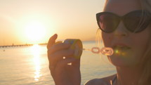 Woman Blowing Soap Bubbles at Sunset