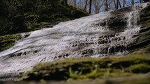 water flowing over mossy rocks 
