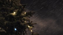 Snowstorm and Christmas tree at night