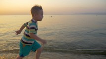 Smiling Boy Running along the Sea