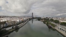 Aerial view over Guadalquivir river, Seville; Sevilla Tower on bank