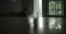 a man sitting quietly thinking and an empty glass 