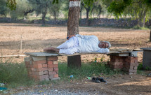 a man sleeping on a bench in Mandawa, India 