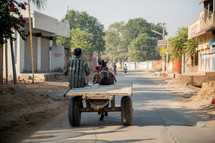 man on a horse drawn wagon in India 