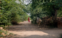 woman walking on a dirt road in India 