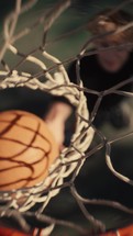 Close up of a basketball being shot on an outdoor basketball court on a sunny day