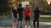 Portrait of smiling young men after playing basketball on a sunny day