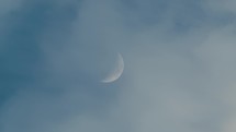 Half Moon in the sky behind the clouds 