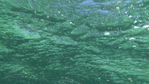 Slow motion shot of wavy sea surface made underwater