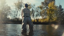 Young fly fisherman casting on a river on a fall morning