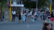 time-lapse of people crossing a street at a crosswalk in a city 