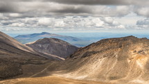 Sunny day with grey clouds sky over volcanic mountains in Tongariro National Park in New Zealand nature landscape Time-lapse with Zoom in transition effect
