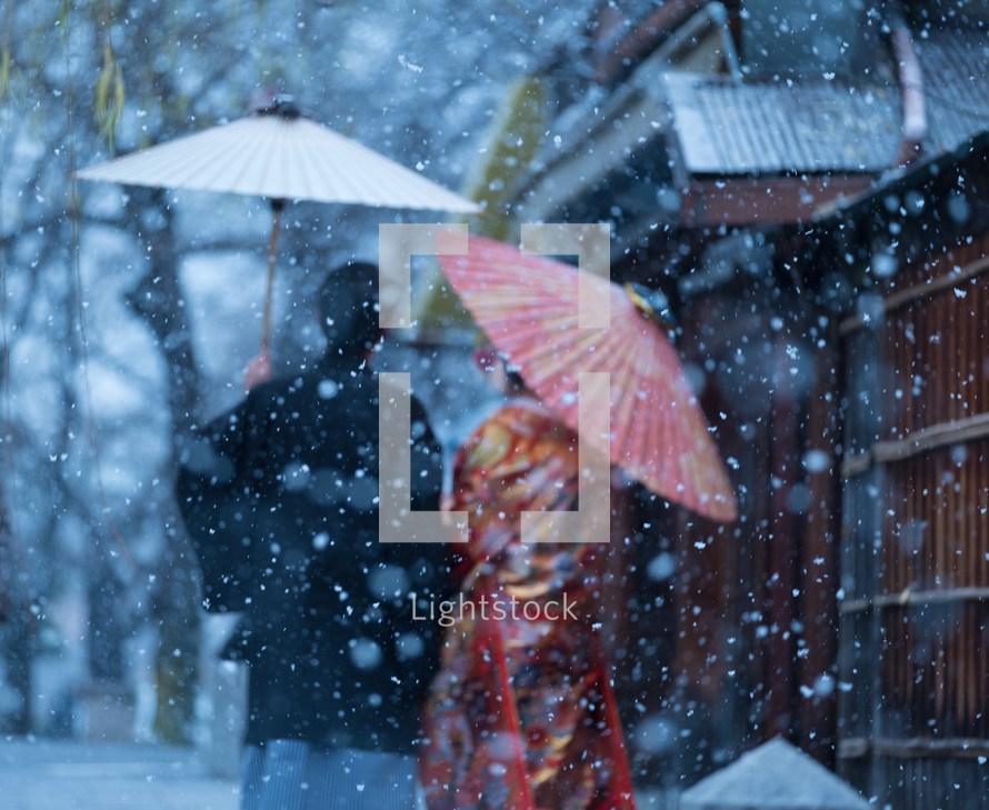 women holding umbrellas in the snow