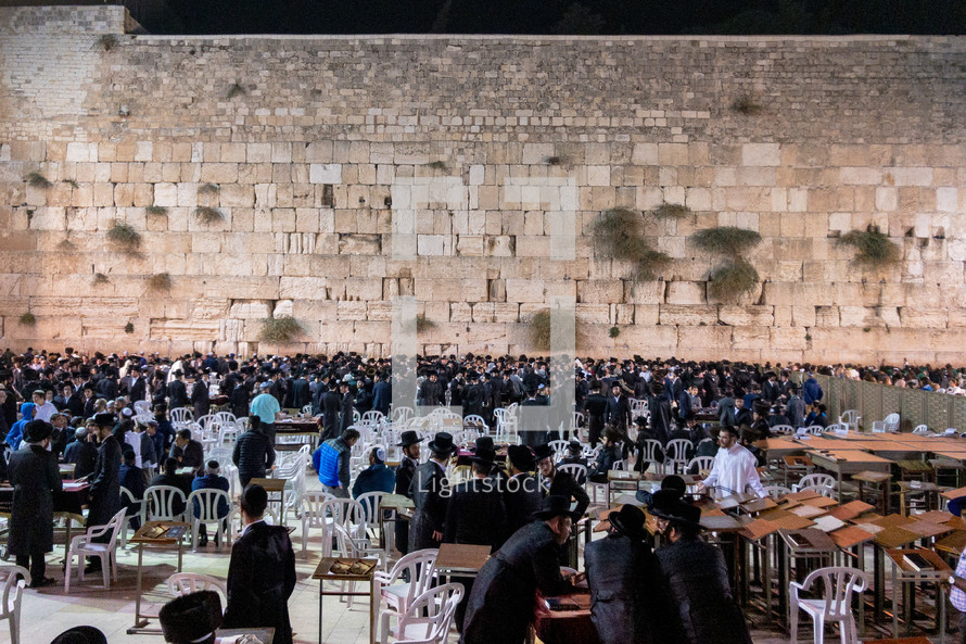 men sitting at the Western wall in Jerusalem 