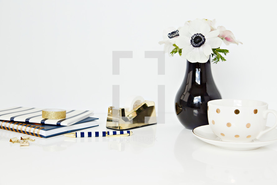 tea cup, tape dispense, gold, clubs, desk, white, flowers, black centers, white background 