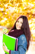 female college student holding an apple 