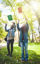 Two female students throw books into the air. End of studies concept.