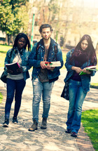 Multiracial group of students walking with books 