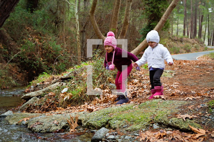 sisters playing by a creek 