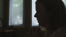 a woman praying at home 