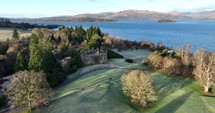 Drone footage of a castle next to Loch Lomond in Scotland.