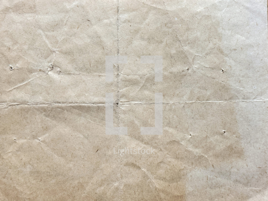 vintage paper with folds, wrinkles and holes - tan color