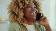 Joyous Woman Drinking Juice and Having Phone Call at Home
