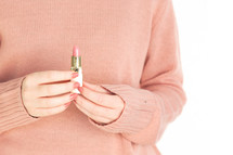 a woman holding lipstick 