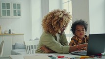 Cute Little Boy Discussing Something on Laptop Screen with Mom at Home
