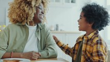 African American Mother and Little Son Having Fun during Breakfast at Home
