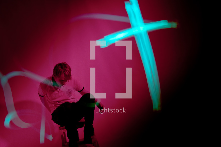 cross in lights in front of a man
