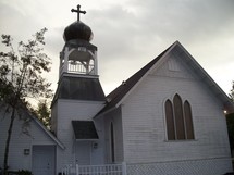 An old historic wooden white church with a cross and stained glass windows used as a wedding chapel in the south.