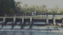 woman waving a white surrender flag with the word Lord over a waterfall dam