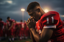 Football player praying before a game