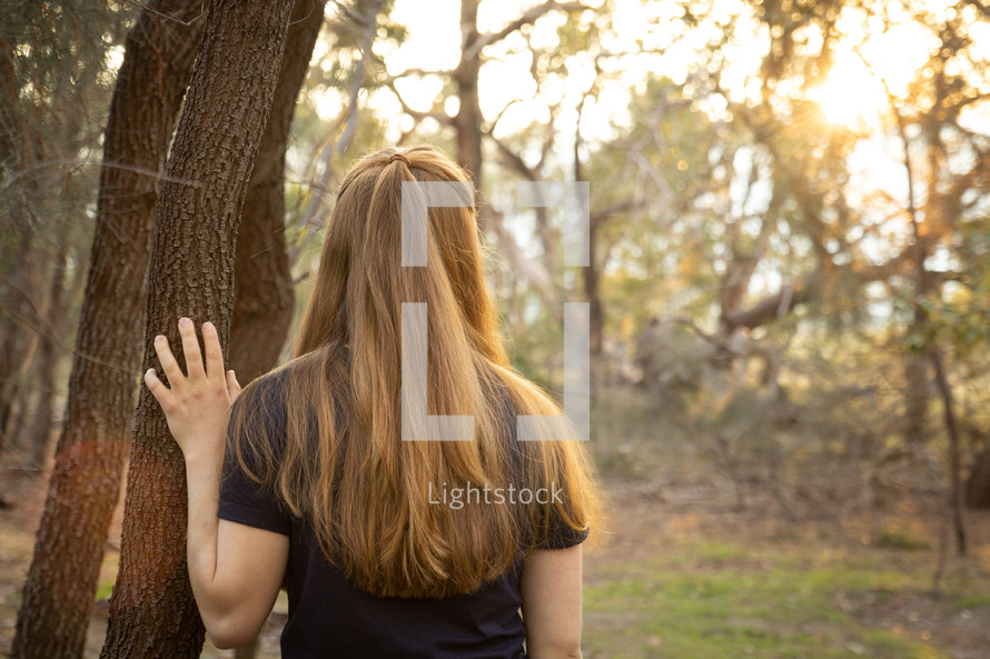 a girl standing alone in the woods 