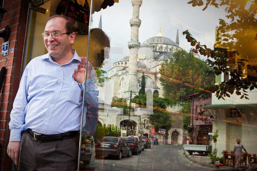 Shop owner with Blue Mosque in window reflection