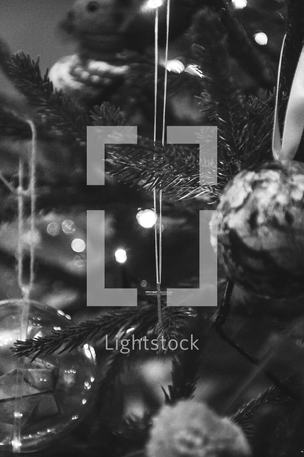 cross necklace hanging in a Christmas tree 