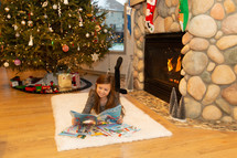 little girl reading a book at Christmas 
