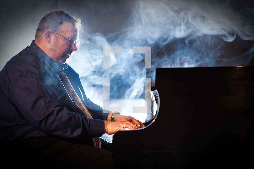 smoke over a man playing a piano